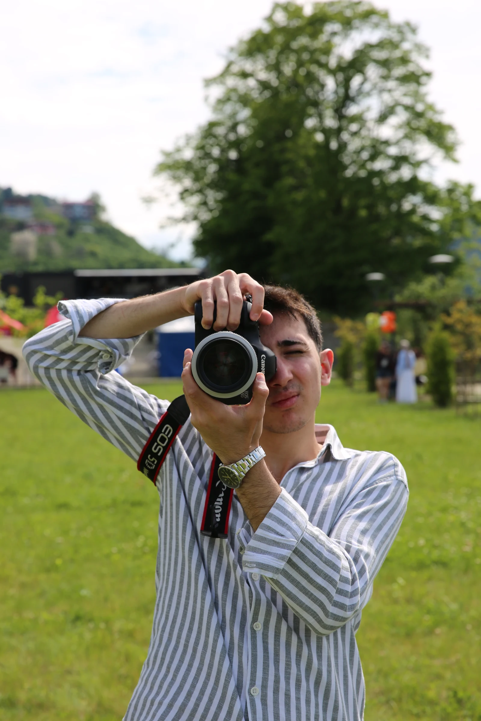 Eren açık havada fotoğraf makinesiyle çekim yaparken